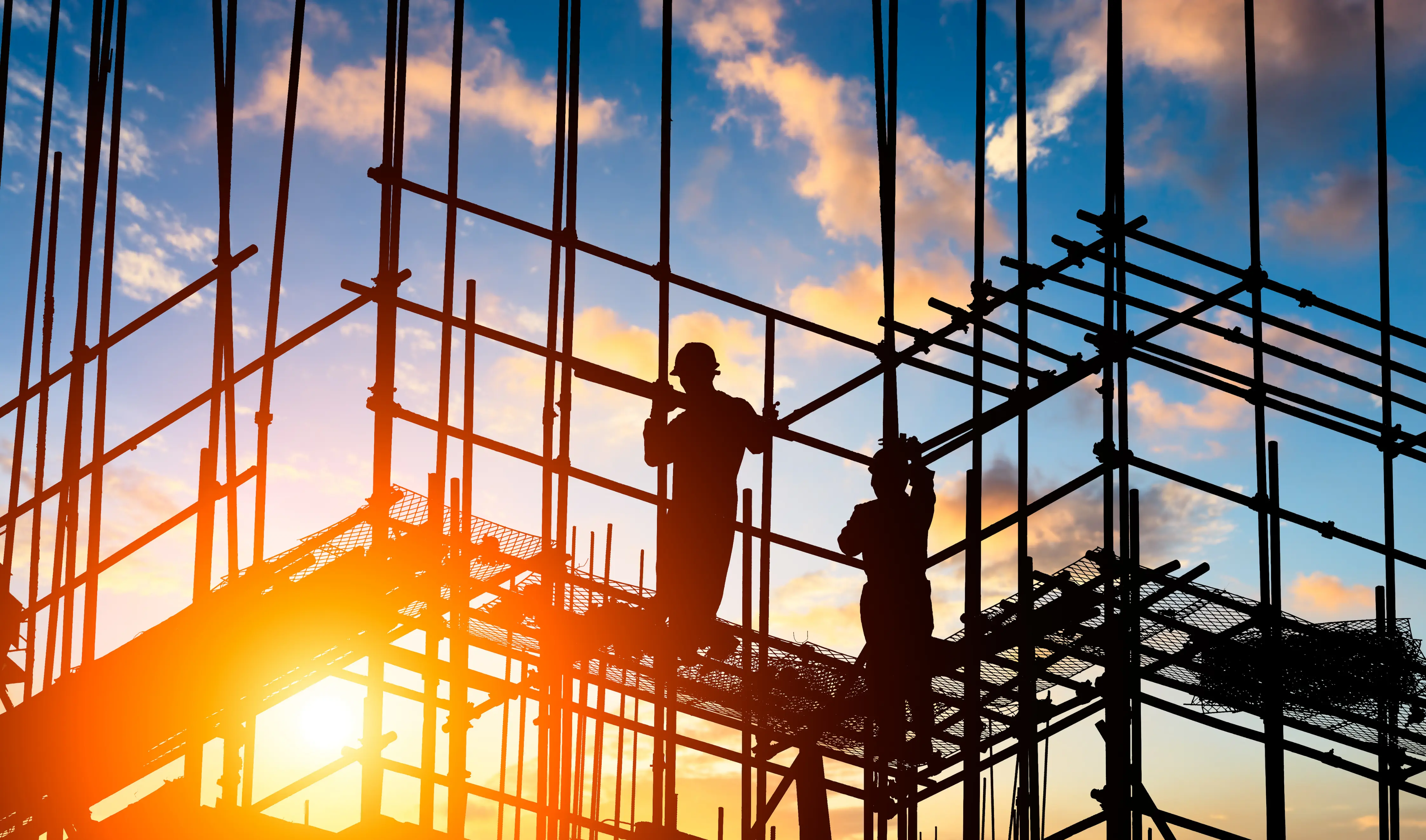 Construction workers at sunset
